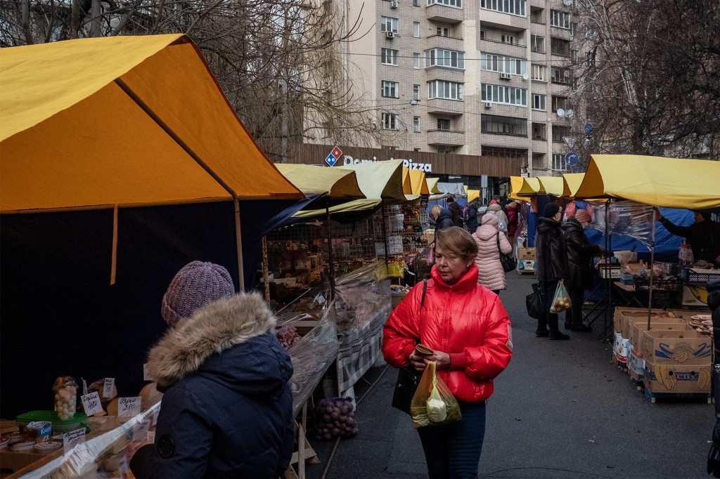 Ludzie robią zakupy na targu outdoorowym w Kijowie pośród napięć między Ukrainą a Rosją 11 lutego 2022 r.
