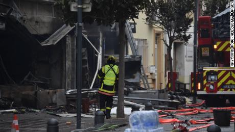 Strażak stoi w pobliżu gruzów i spalonych domów po wybuchu w Saint-Laurent-de-la-Salanque, 14 lutego 2022 r. 