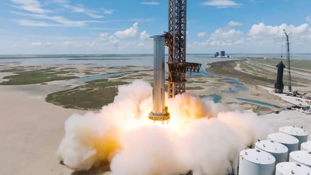 A static fire test of SpaceX Booster 7 showing the giant rocket belching flame