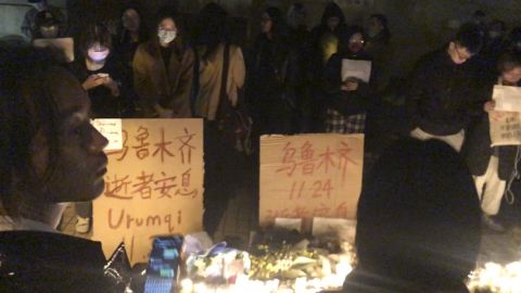 Protestujący stoją przy znakach protestu w Szanghaju, Chiny, w sobotę, 26 listopada 2022 r. 